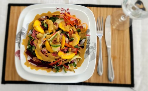 A plate of colorful peach and vegetable salad