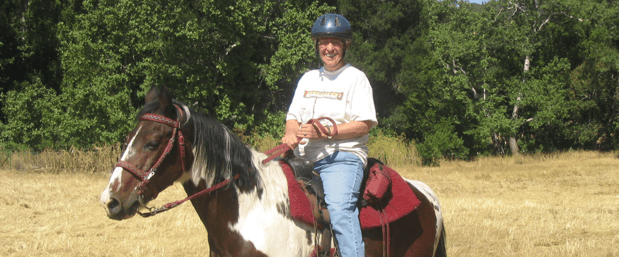 kitty monahan enjoying a trail ride on her horse